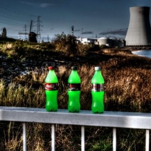 Nuclear coke is a series of photos where different bottles of Coca Cola are placed in the vicinity of a nuclear power plant with the typical cooling towers. In this case it's the nuclear power plant of Doel near Antwerp. Apart from the HDR effect that was added afterwards, no photo editing was applied here. The bottles are real, actually stand on that railing and are containing green Halloween make-up that Ghost dissolved in water. The three bottles can still be found in Ghost's house today, in the bathroom somewhere on top of a cupboard.