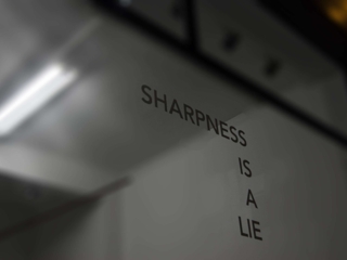 Sharpness Is A Lie Ghost was returning from a nightly reportage, and on his way home by foot, when he suddenly saw this window with that text on it, and captured it forever. Is sharpness a lie? You have to decide that for yourself.